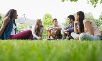 Group of students sat on some grass