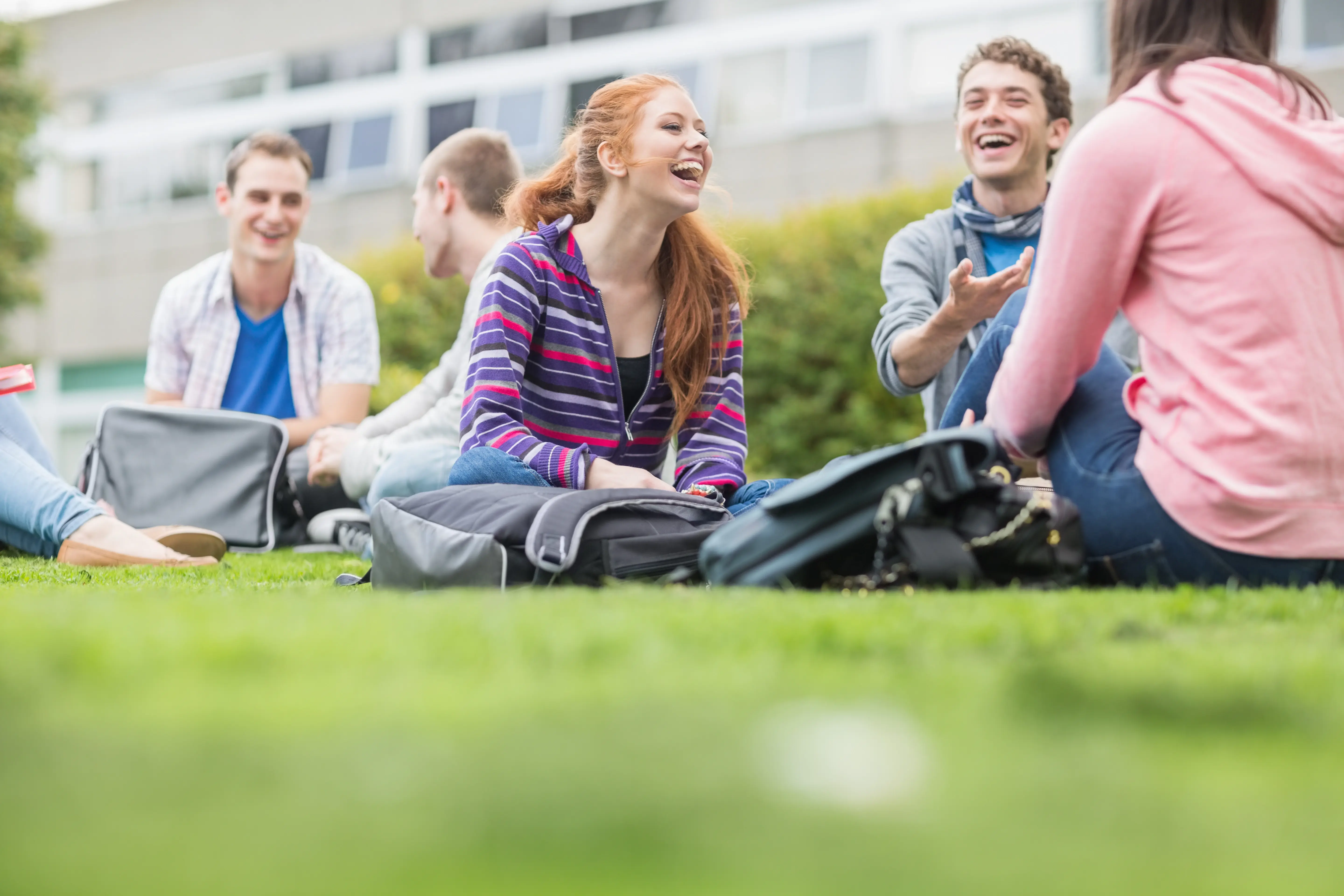 Students sat in groups outdoors, laughing